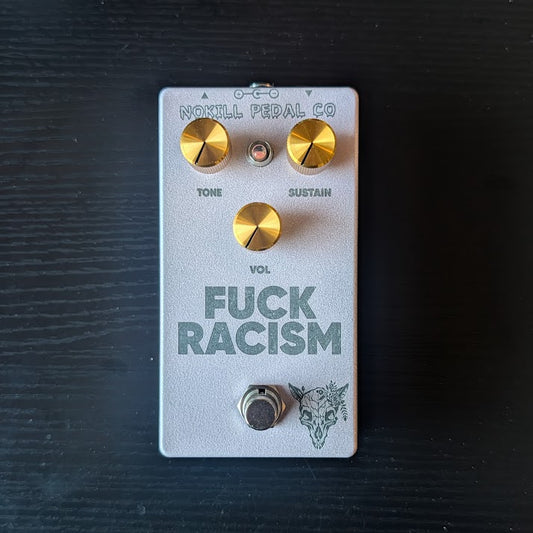 FUCK RACISM - a silver sparkle NOKILL fuzz pedal with gold Tone, Sustain and Vol knobs and an engraved wolf skull wreathed in flowers.